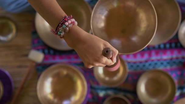 亚洲圣药女大师的超慢动作镜头表演藏碗疗伤仪式。用藏语唱碗冥想。她坐在凉亭冥想与一个美丽的 — 图库视频影像