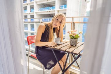 Balkondaki genç kadın binanın dışında çalışıyor. Gürültü kavramı. Bina tozundan kaynaklanan hava kirliliği