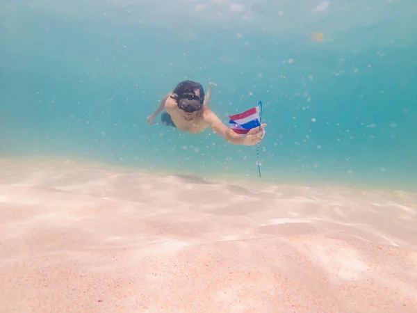 Šťastný muž se šnorchlováním masek pod vodou s tropickými rybami s thajskou vlajkou v mořském bazénu korálového útesu. Cestovní životní styl, vodní sport venkovní dobrodružství, lekce plavání na letních plážových prázdninách — Stock fotografie