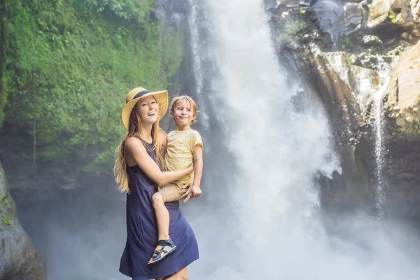 Moeder en zoon toeristen op de achtergrond van een waterval. Reizen met Kids concept. Wat te doen met kinderen kinderen vriendelijke plek — Stockfoto