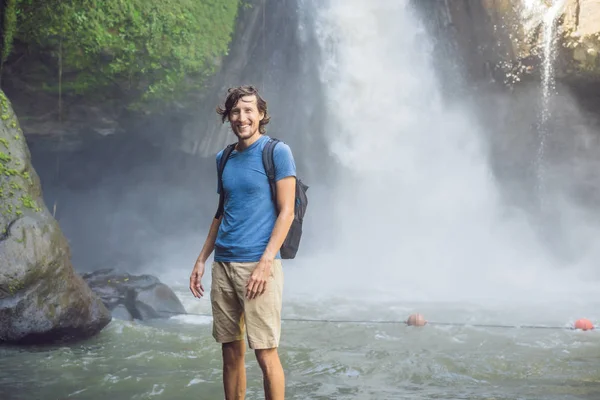 Hombre viajero en un fondo de cascada. Concepto de ecoturismo — Foto de Stock