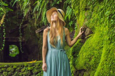 Yosunla büyümüş bali bahçesinde genç bir kadın gezgin. Bali konseptine seyahat