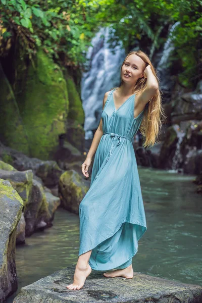 Kobieta samotnie na tle wodospadu. Koncepcja ekoturystyki — Zdjęcie stockowe