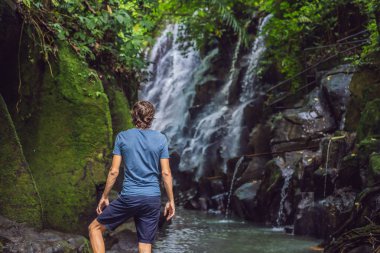 Şelale nin arka planında gezgin bir adam. Ekoturizm kavramı