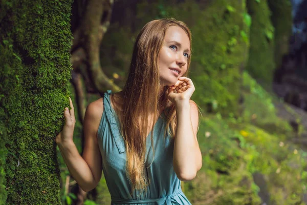 Young woman traveler in a Balinese garden overgrown with moss. Travel to Bali concept — Stock Photo, Image