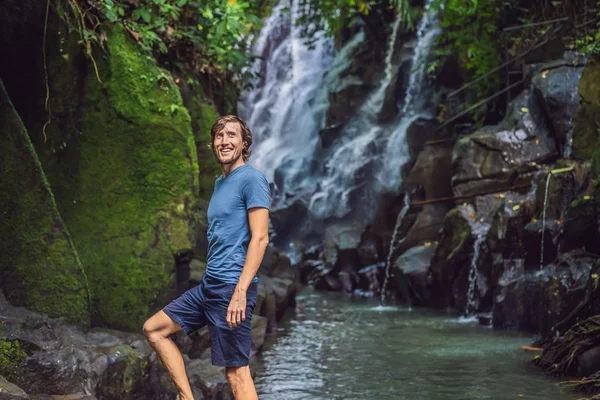 Man reiziger op een waterval achtergrond. Ecotourism concept — Stockfoto