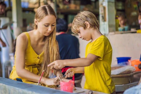 Matka a syn dělají keramický hrnec v keramice. Co dělat s dětmi. Dětské přátelské místo — Stock fotografie