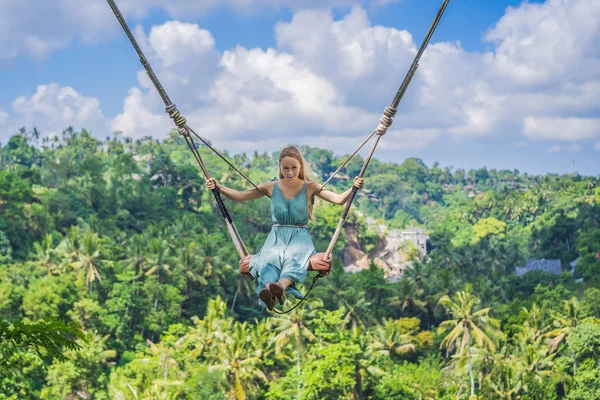 Молодая женщина, раскачивающаяся в джунглях тропического леса острова Бали, Индонезия. Качели в тропиках. Качели - тренд Бали — стоковое фото