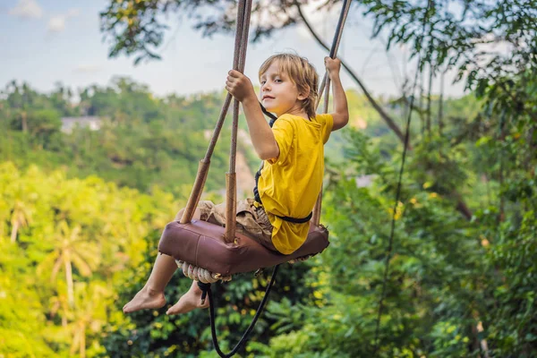 Мальчик, качающийся в джунглях тропического леса острова Бали, Индонезия. Качели в тропиках. Качели - тренд Бали. Путешествуя с детьми концепции. Что делать с детьми. Место, благоприятное для детей — стоковое фото