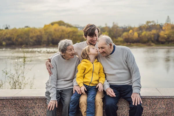 Pareja mayor con nieto y bisnieto en el parque de otoño. Bisabuela, bisabuelo y bisnieto — Foto de Stock