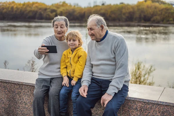 Ανώτερος ζευγάρι με δισέγγονος τράβηξε μια selfie στο πάρκο φθινόπωρο. Μεγάλος-γιαγιά, προπάππους και δισέγγονος — Φωτογραφία Αρχείου