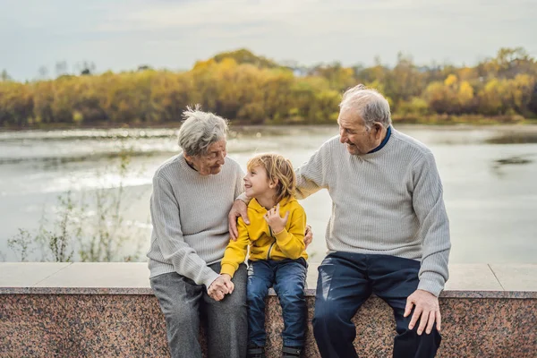 Pareja mayor con nieto en el parque de otoño. Bisabuela, bisabuelo y bisnieto — Foto de Stock