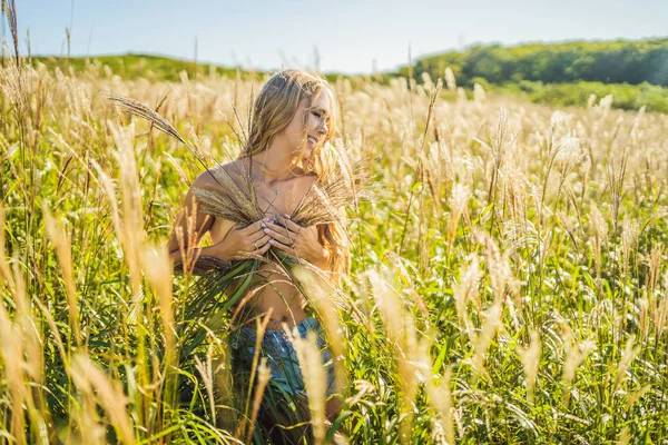 Młoda piękna kobieta w jesień krajobraz z suchych kwiatów, pszenicy kolce. Moda Jesień, zima. Słoneczny, Fotografia mody — Zdjęcie stockowe