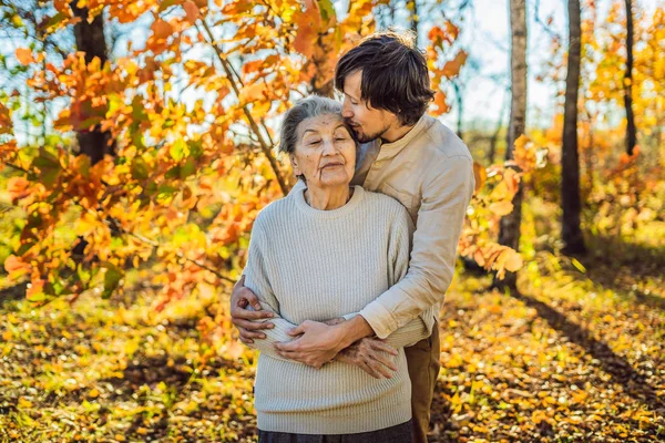 가을 공원에서 포옹하는 할머니와 성인 손자 — 스톡 사진