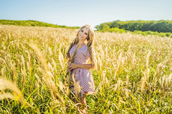 Mujer hermosa joven en el paisaje de otoño con flores secas, espigas de trigo. Moda otoño, invierno. Otoño soleado, foto de moda —  Fotos de Stock