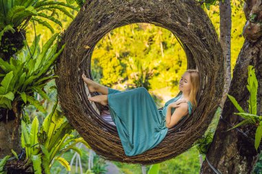 Bali trendi, her yerde saman yuvaları. Genç turist Bali adası, Endonezya etrafında onu seyahat zevk. Güzel bir tepede mola. Saman yuvasında fotoğraf, doğal bir çevre. Yaşam tarzı