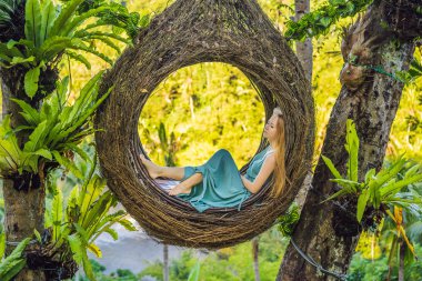 Bali trendi, her yerde saman yuvaları. Genç turist Bali adası, Endonezya etrafında onu seyahat zevk. Güzel bir tepede mola. Saman yuvasında fotoğraf, doğal bir çevre. Yaşam tarzı