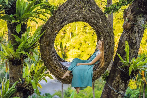 Bali trend, straw nests everywhere. Young tourist enjoying her travel around Bali island, Indonesia. Making a stop on a beautiful hill. Photo in a straw nest, natural environment. Lifestyle