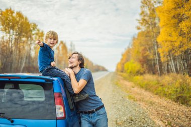 Babam ve oğlum yol kenarında bir yolculuğa dinleniyorlar. Çocuk konsepti ile yol gezisi