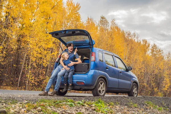 Papá e hijo están descansando al lado de la carretera en un viaje por carretera. Viaje por carretera con concepto de niños — Foto de Stock