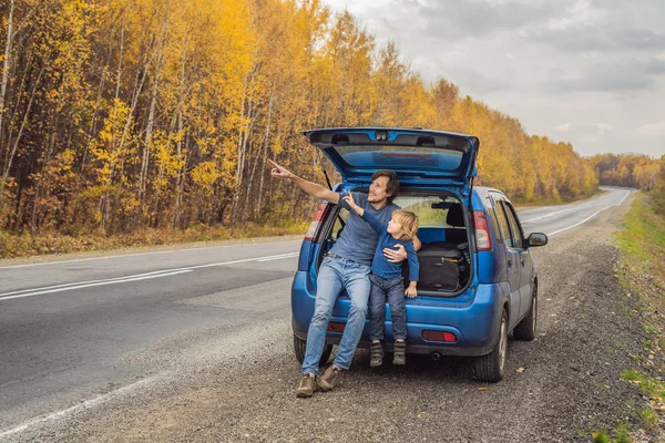 Papá e hijo están descansando al lado de la carretera en un viaje por carretera. Viaje por carretera con concepto de niños — Foto de Stock