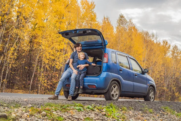 Papá e hijo están descansando al lado de la carretera en un viaje por carretera. Viaje por carretera con concepto de niños — Foto de Stock