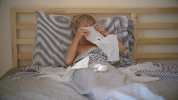 Tiro em câmara lenta de um rapazinho doente numa cama. Conceito de gripe infantil — Vídeo de Stock