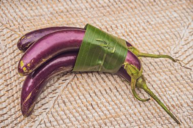 Çevre dostu ürün ambalaj konsepti. Patlıcan bir muz yaprağı sarılmış, plastik bir torba alternatif olarak. Sıfır atık kavramı. Alternatif ambalaj