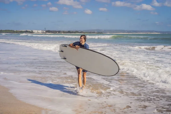 Surfista con la tavola da surf che corre verso le onde — Foto Stock