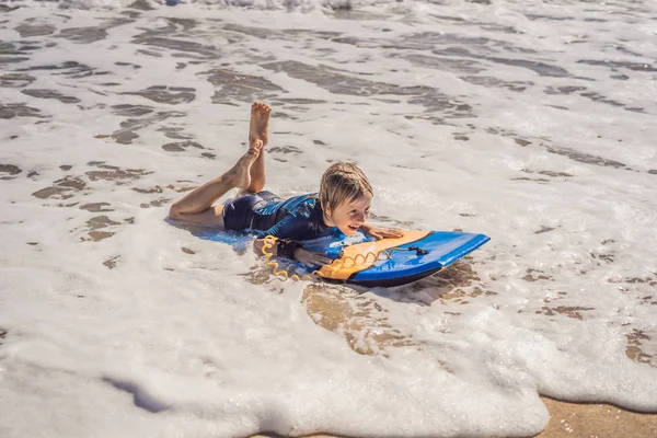 Niño feliz divirtiéndose en la playa de vacaciones, con boogie board —  Fotos de Stock