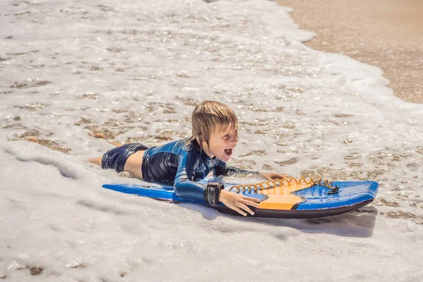 Joyeux jeune garçon qui s'amuse à la plage en vacances, avec boogie board — Photo