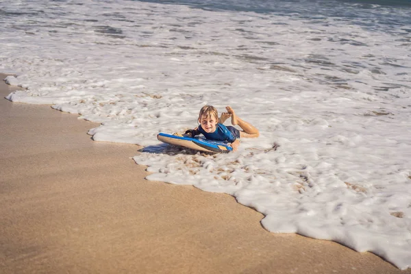 浜の休暇は、ブギー ボード上で楽しんで幸せな少年 — ストック写真