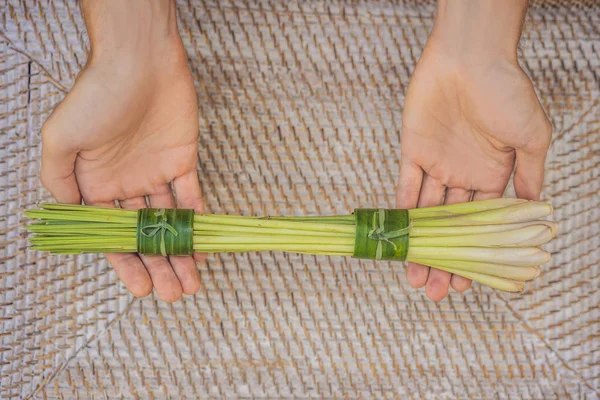 Eco-friendly product packaging concept. Lemongrass wrapped in a banana leaf, as an alternative to a plastic bag. Zero waste concept. Alternative packaging