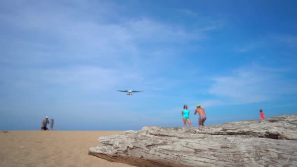 Superslowmotion disparo de una playa tropical donde los aviones vuelan sobre los turistas se dirige antes de aterrizar en un aeropuerto — Vídeo de stock