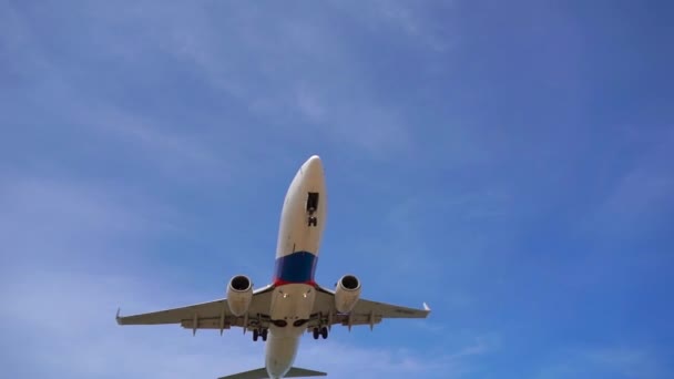 飛行機が空港に着陸する前に観光客の頭の上を飛ぶ熱帯のビーチのスーパースローモーションショット — ストック動画