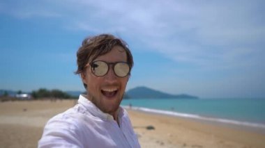Mutlu bir turist Superslowmotion çekim onun üzerinde uçan bir uçak ile tropikal bir plajda eğlenin