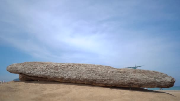 Superslowmotion shot van een tropisch strand waar vliegtuigen vliegen over toeristen hoofden voor land in een luchthaven — Stockvideo