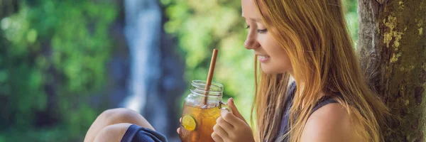 Primo piano ritratto immagine di una bella donna che beve tè freddo con sensazione di felicità nella natura verde e cascata giardino sfondo BANNER, FORMATO LUNGO — Foto Stock