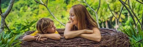 BANNER, FORMATO LARGO tendencia Bali, nidos de paja en todas partes. Familia feliz disfrutando de su viaje por la isla de Bali, Indonesia. Haciendo una parada en una hermosa colina. Foto en un nido de paja, ambiente natural — Foto de Stock