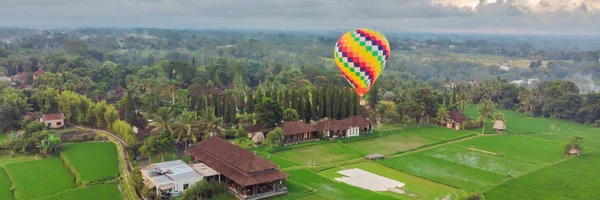 Yeşil çeltik alanı üzerinde sıcak hava balonu. Doğanın bileşimi ve mavi gökyüzü arka plan. Seyahat konsepti Banner, Uzun Format — Stok fotoğraf