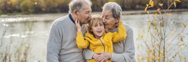BANNER, FORMATO LUNGO Coppia di anziani con nipotino nel parco autunnale. bisnonna, bisnonno e pronipote — Foto Stock