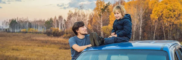 BANNER, LONG FORMAT Pai e filho estão descansando no lado da estrada em uma viagem de carro. Viagem de carro com conceito de crianças — Fotografia de Stock