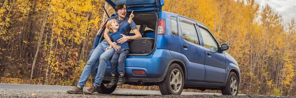 BANNER, FORMATO LARGO Papá e hijo están descansando en el lado de la carretera en un viaje por carretera. Viaje por carretera con concepto de niños — Foto de Stock