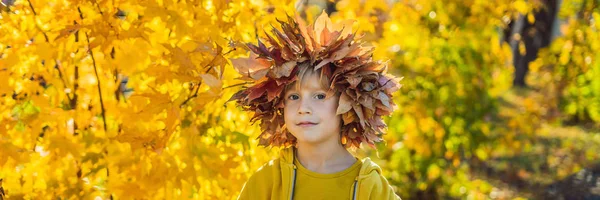 Portrait of little smiling child with wreath of leaves on head background of sunny autumn park BANNER, LONG FORMAT — Stock Photo, Image