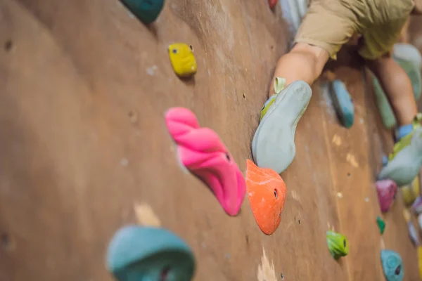 Rapazinho a escalar uma parede de pedra com botas especiais. interior — Fotografia de Stock