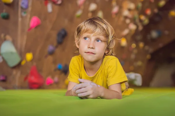 Boy resting after climbing a rock wall indoor — Stock Photo, Image