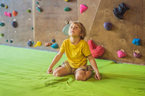 Niño descansando después de escalar una pared de roca interior —  Fotos de Stock