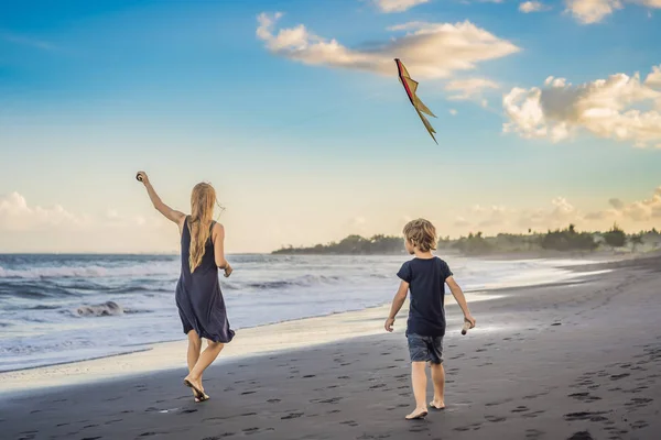Una giovane donna lancia un aquilone sulla spiaggia. Sogno, aspirazioni, progetti futuri — Foto Stock