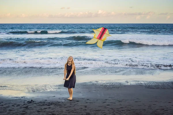 Egy fiatal nő indít kite a strandon. Álom, törekvések, jövőbeli tervek — Stock Fotó