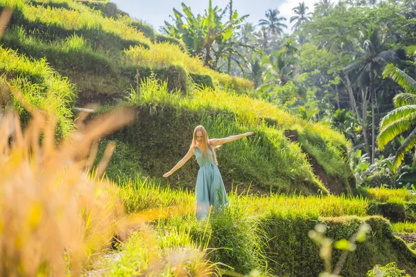 Schöne junge Frau zu Fuß an typisch asiatischen Berghang mit Reisanbau, Bergform grüne Kaskade Reisfeld Terrassen Reisfelder. ubud, bali, indonesien. bali Reisekonzept — Stockfoto